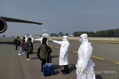 2월 2일 인도 뉴델리에서 공항 관계자가 중국 우한에서 돌아온 자국민의 체온을 재고 있는 모습. [AFP=연합뉴스]