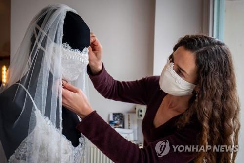 베를린의 웨딩복 디자이너가 마네킹에 자체 제작한 마스크를 씌우고 있는 모습 [AFP=연합뉴스 자료사진]