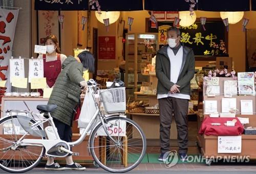 (도쿄 EPA=연합뉴스) 신종 코로나바이러스 감염증(코로나19)이 확산하는 가운데 3일 일본 도쿄도(東京都)에서 마스크를 쓴 남성이 상점 앞에 서 있다. 2020.4.5