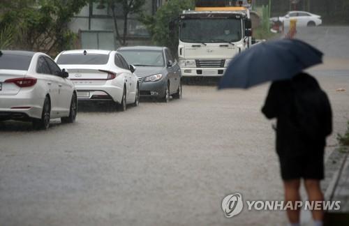 강원 영동지방을 중심으로 많은 비가 내린 30일 오전 강릉 시내에서 시민이 출근길을 재촉하고 있다. 2020.6.30