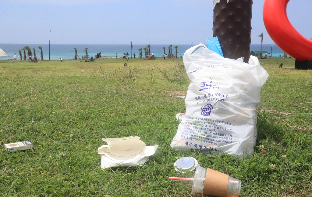 6월 28일 제주시 함덕해수욕장의 모습. 해수욕장 야자수 아래 쓰레기가 놓여있다.