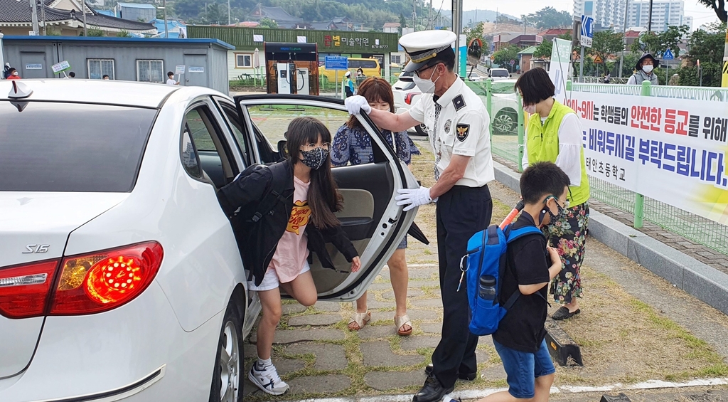 태안초 앞 주차장에서 하차 어린이 돕는 경찰관