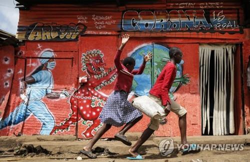 지난 6월 3일 케냐 나이로비에서 '코로나19 주의' 벽화 앞을 달려가고 있다. 