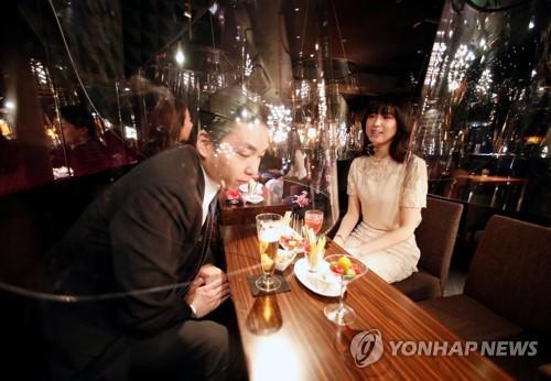 아크릴 차단막 사이로 접객하는 여성 종업원