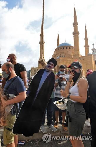 8일(현지시간) 레바논 수도 베이루트에서 반정부 시위대가 이슬람 시아파 정파인 헤즈볼라 지도자 하산 나스랄라의 초상화에 올가미를 거는 퍼포먼스를 하고 있다.[AFP=연합뉴스]