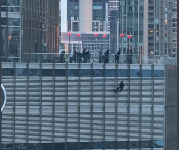 미국 시카고 트럼프타워 16층 난간에서 한 남성이 밧줄에 의존해 매달려 있다.