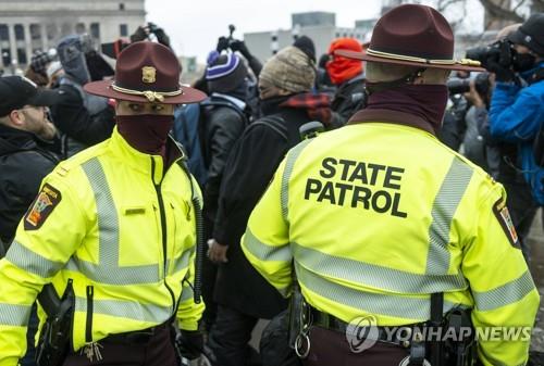16일(현지시간) 미 미네소타주 세인트폴에서 경찰관들이 친트럼프 시위대와 반트럼프 시위대 간 다툼을 말리고 있다. [AFP=연합뉴스]