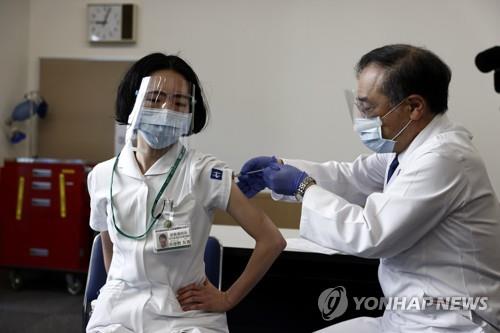 (도쿄 AP=연합뉴스) 일본이 코로나19 백신 접종을 개시한 지난 17일 도쿄에서 한 의료종사자(왼쪽)가 백신을 접종받고 있다. 