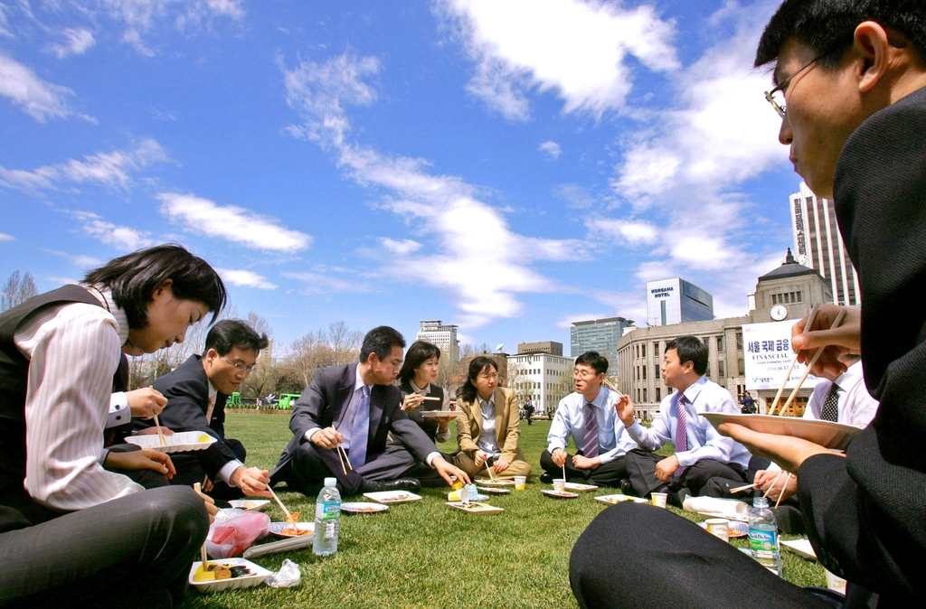 서울광장 잔디밭에 직장인들이 둘러앉아 도시락을 먹고 있다. 2006년 [연합뉴스 자료사진]