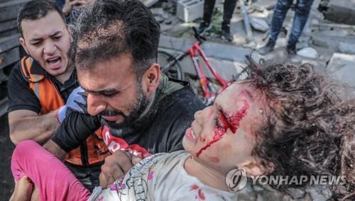 이스라엘의 폭격으로 무너진 건물 더미에서 구해낸 딸을 안은 가자 지구 주민