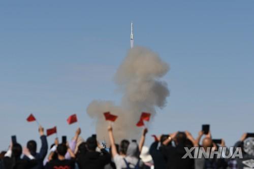 오성홍기를 흔들며 발사장면을 지켜보는 중국인들