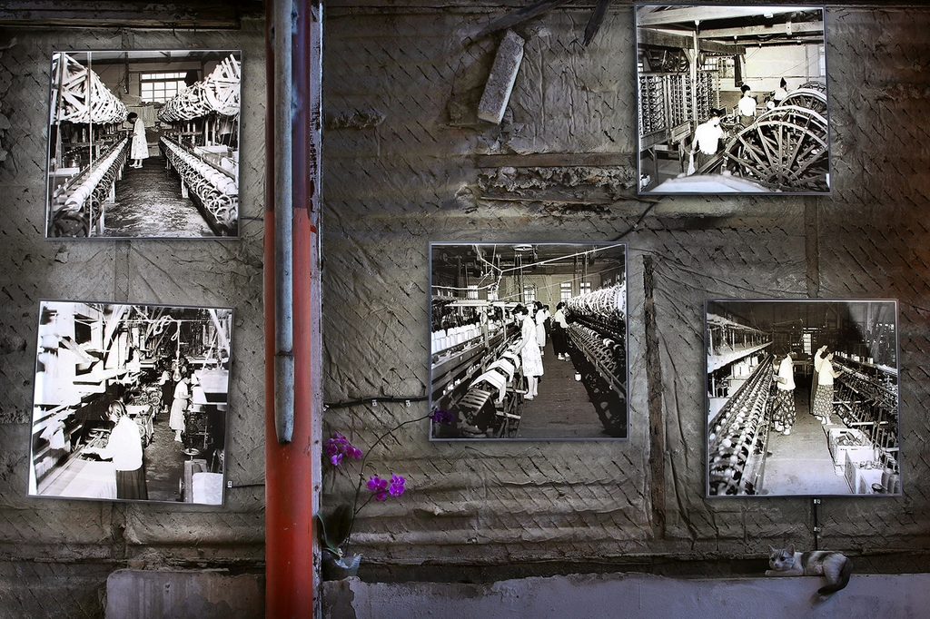 긴 작업대 앞에서 여공들이 기계를 돌리던 모습이 카페 한쪽 벽면에 걸린 흑백사진 속에 담겨 있다. [사진/전수영 기자]