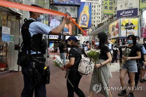 2일 홍콩 시민들이 경찰관 피습사건이 발생한 코즈웨이베이 사건 현장을 찾아 헌화하는 모습.[AP=연합뉴스]