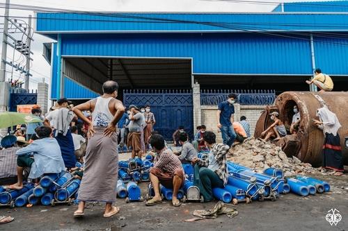 산소 공장 앞에서 산소통을 들고 기다리는 미얀마 시민들.