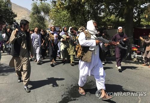 총 들고 아프간 시위대 향하는 탈레반 대원들