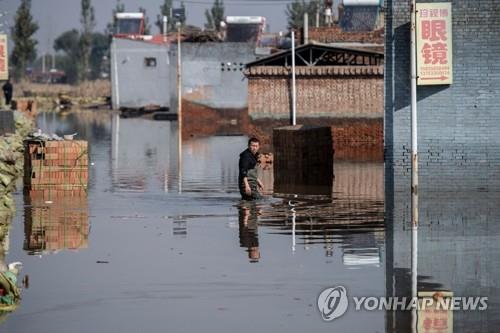 중국 산시성 홍수 피해 지역 걸어가는 주민