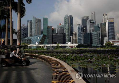 거리두기를 위한 X표시가 된 공원 벤치 뒤로 보이는 싱가포르 고층 건물들(자료사진