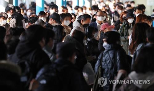 El 14 de marzo de 2023, los pasajeros caminan, llevando puestas mascarillas, por una estación del metro de Seúl.