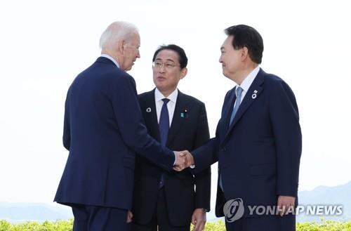 La foto de archivo muestra al presidente surcoreano, Yoon Suk Yeol (dcha.), hablando con su homólogo estadounidense, Joe Biden (izda.), y el primer ministro japonés, Fumio Kishida, antes de su diálogo trilateral, celebrado, el 21 de mayo de 2023, en Hiroshima, Japón. (Foto del cuerpo de prensa. Prohibida su reventa y archivo)