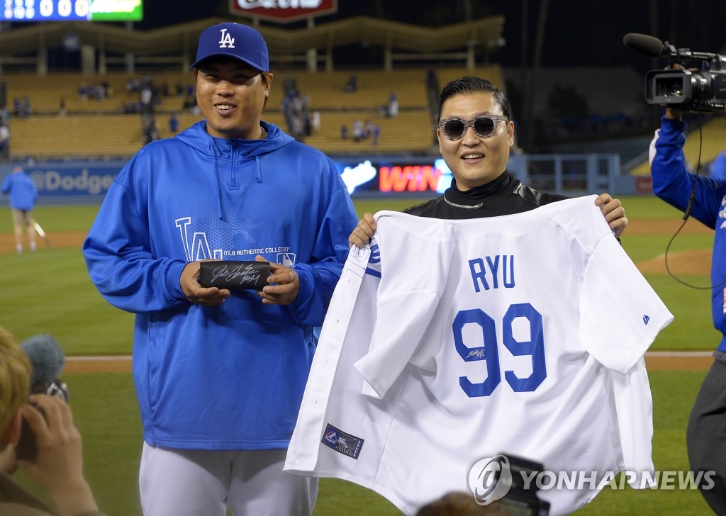 미국 로스앤젤레스 다저스타디움에서 싸이가 류현진의 유니폼을 들고 기념촬영을 하고 있다.(AP=연합뉴스)