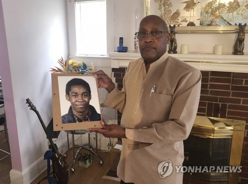 숨진 아들 아스키아 카프라의 사진을 들고 있는 아버지