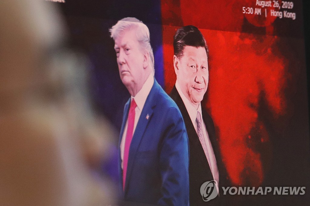 2019년 8월 26일 서울 KEB 하나은행 딜링룸에 설치된 모니터에 도널드 트럼프 미국 대통령(왼쪽)과 시진핑 중국 국가주석(오른쪽)의 이미지가 비치고 있다. [AP=연합뉴스자료사진]