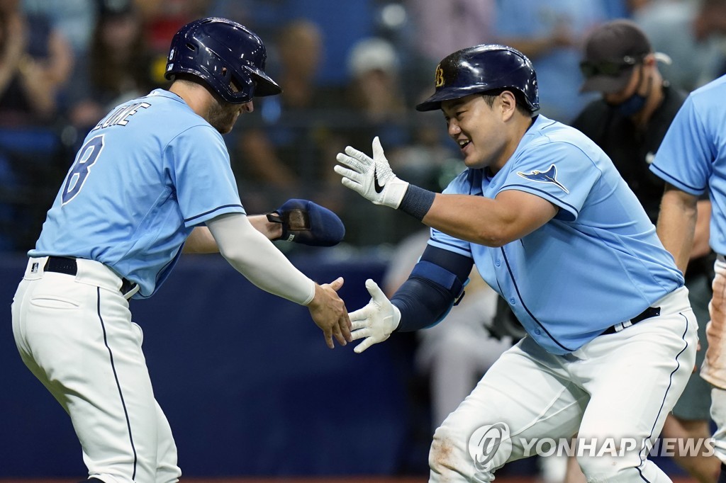 In this Associated Press photo, Choi Ji-man of the Tampa Bay Rays (R) celebrates his three-run home run off Adam Oller of the Oakland Athletics with teammate Brandon Lowe during the bottom of the second inning of a Major League Baseball regular season game at Tropicana Field in St. Petersburg, Florida, on April 12, 2022. (Yonhap)