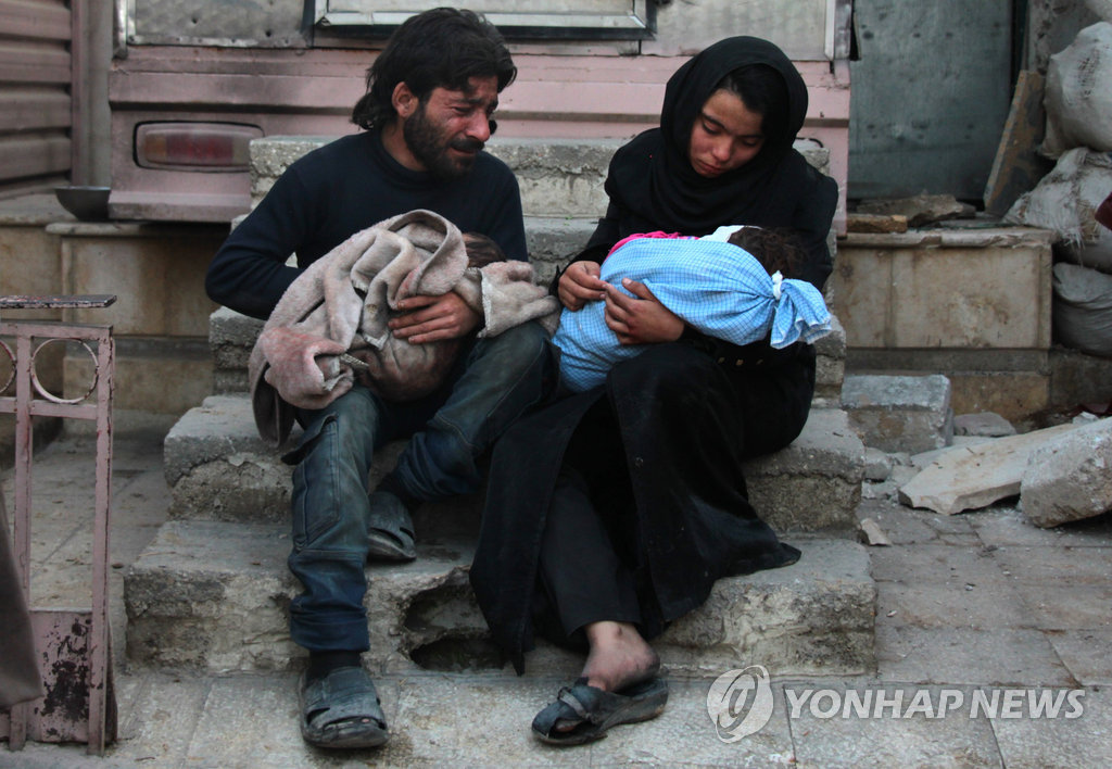공습에 숨진 아기(오른쪽)를 안고 슬퍼하는 시리아 동구타의 부부