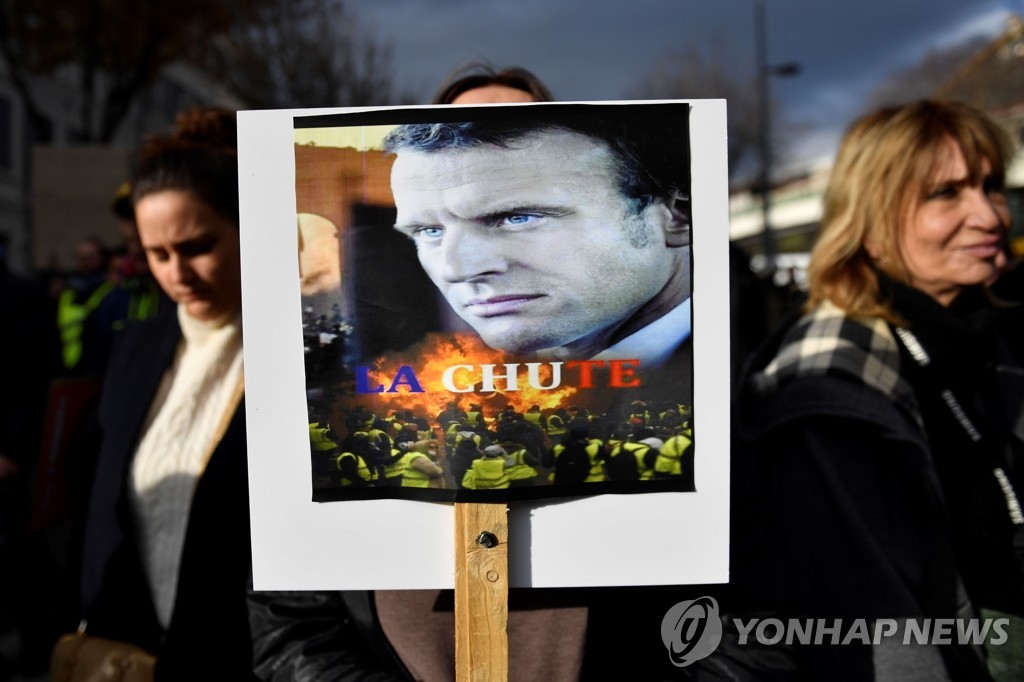 5일 프랑스 남부 마르세유의 연금개편 반대 집회에서 시위대가 에마뉘엘 마크롱 대통령의 얼굴을 인쇄한 종이에 '추락'이라고 쓴 글자를 들어보이고 있다. [AFP=연합뉴스]