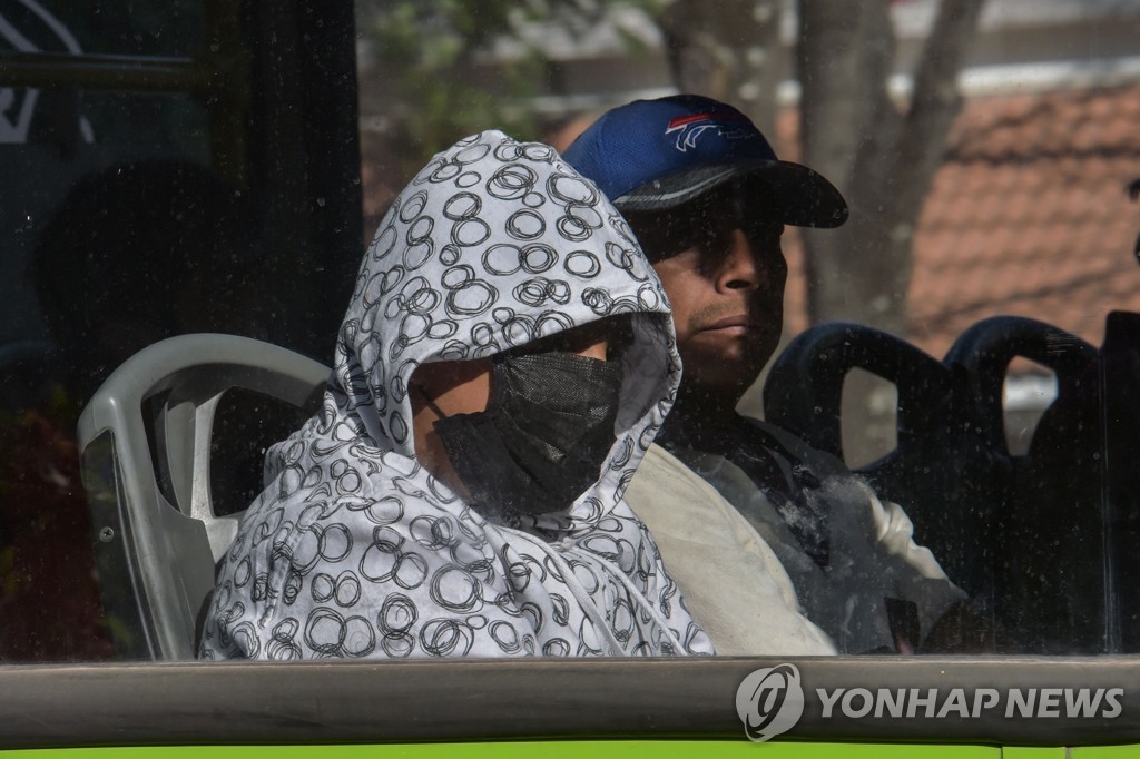 2020년 3월 26일 멕시코 시티에서 마스크를 쓴 여성이 버스를 타고 있다. [AFP=연합뉴스자료사진]
