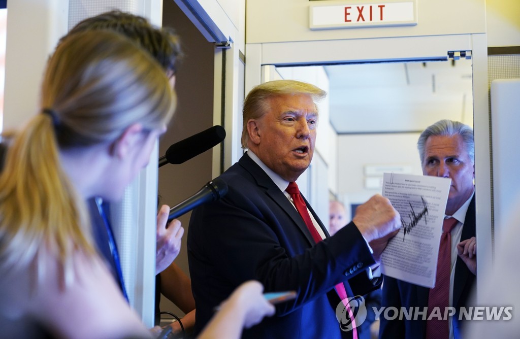 This AFP photo shows U.S. President Donald Trump speaking to reporters aboard Air Force One en route to Andrews Air Force Base, Maryland, on May 30, 2020. (Yonhap)