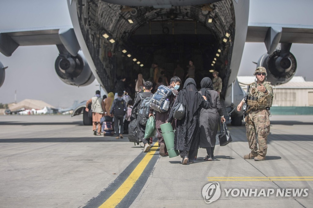 23일(현지시간) 아프가니스탄 카불 하미드 카르자이 국제공항에서 미군 수송기에 탑승하는 아프간인들. [미 해병대/AFP=연합뉴스]