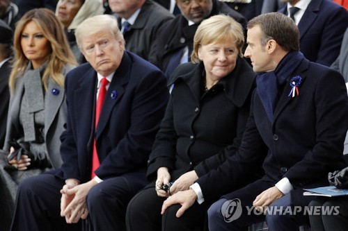 지난 11일 파리 개선문에서 열린 1차대전 종전 100주년 기념식에서 앙겔라 메르켈 독일 총리(가운데)와 친밀하게 대화하는 에마뉘엘 마크롱 프랑스 대통령(오른쪽), 도널드 트럼프 미국 대통령(왼쪽에서 두번째)[EPA=연합뉴스]
