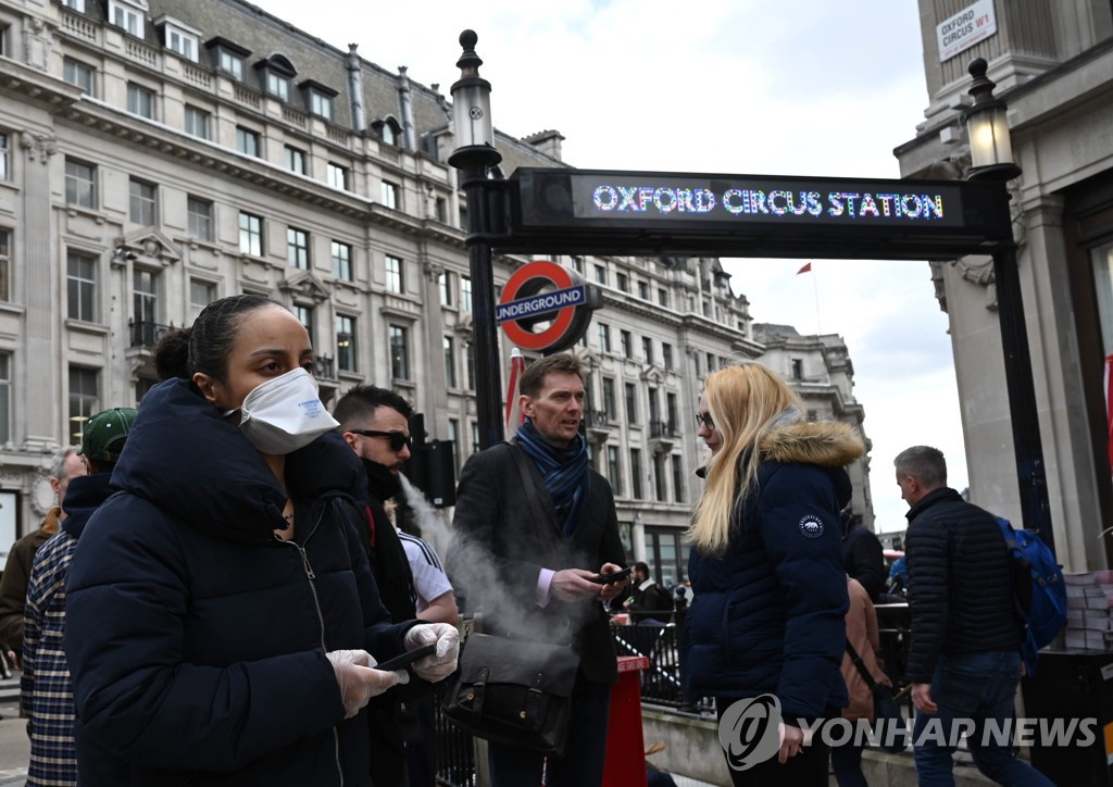 런던 옥스퍼드 가 지하철 역앞을 마스크를 쓰고 지나가는 행인 [EPA=연합뉴스]