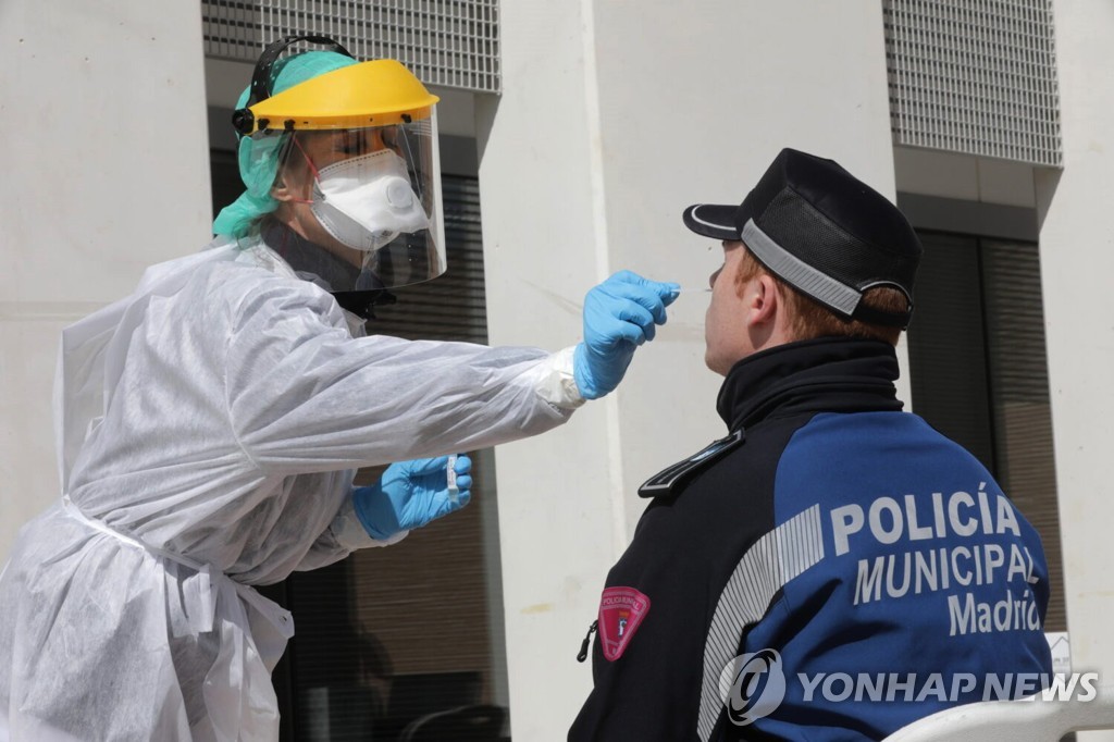 지난 25일 스페인 마드리드에서 한 경찰관이 코로나19 검사를 받는 모습. [마드리드시 제공·EPA=연합뉴스. 재판매 및 DB 금지]