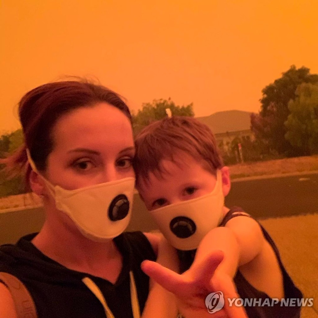 호주 산불 연기에 오염된 공기 때문에 마스크를 쓴 호주인 모자 