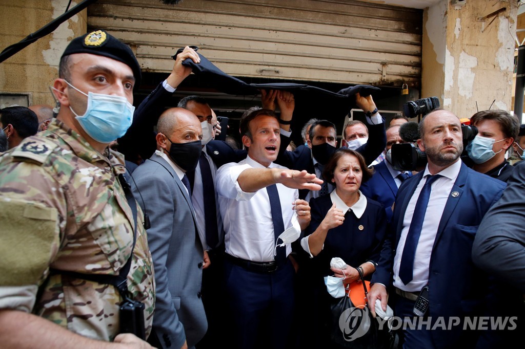 지난 6일 레바논 베이루트의 폭발 현장을 찾은 에마뉘엘 마크롱 프랑스 대통령(가운데) [로이터=연합뉴스 자료사진]