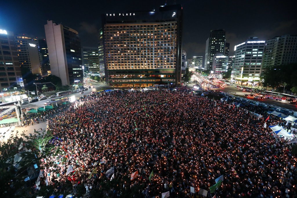 지난 14일 오후 서울광장에서 열린 국정원 대선개입 규탄 7차 범국민대회 참석자들이 촛불을 들고 있다. <<연합뉴스DB>>