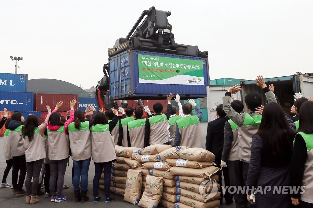 １４年３月１２日、仁川で北朝鮮に送る人道支援物資を積んだコンテナが運ばれている＝（聯合ニュース）