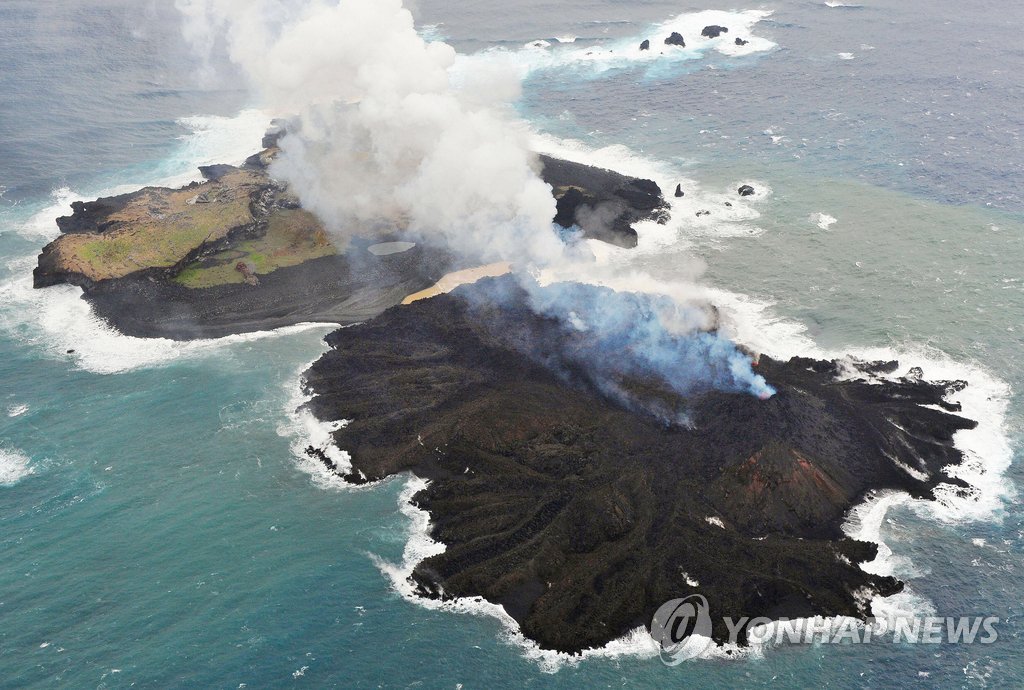 일본 해저 화산 폭발로 생긴 섬이 용암 분출로 계속 성장 중인 모습(오른쪽 앞). 2013년 12월 31일 촬영한 사진으로 지난해 11월 모습과 비교해 크기 차이가 뚜렷하다. (교도=연합뉴스) 