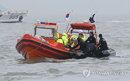 지난달 17일 세월호가 침몰한 전남 진도군 조도면 병풍도 북쪽 3km 앞 사고 해상에서 구조작업을 벌이던 해군 해난구조대(SSU)와 해경이 시신 한 구를 발견해 옮기고 있다.