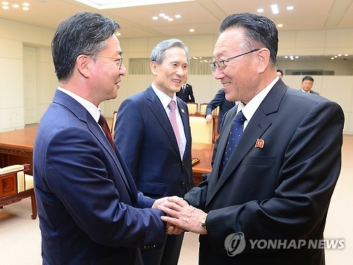 홍용표 통일부 장관과 북측 김양건 당 비서(오른쪽)가 25일 오전 판문점에서 '무박4일' 마라톤 협상을 마치고 악수하고 있다. (연합뉴스 자료사진)