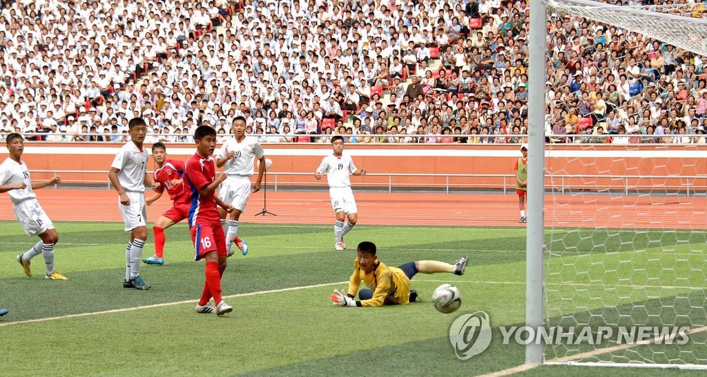 지난해 8월 24일 북한 평양 능라도 5.1경기장에서 열린 2015 제2회 국제 유소년 U-15(15세 이하) 축구대회 결승전 4.25체육단(붉은유니폼)과 평양국제축구학교의 결승전에서 4.25 체육단 선수가 골을 넣고 있다. <<연합뉴스 DB>>