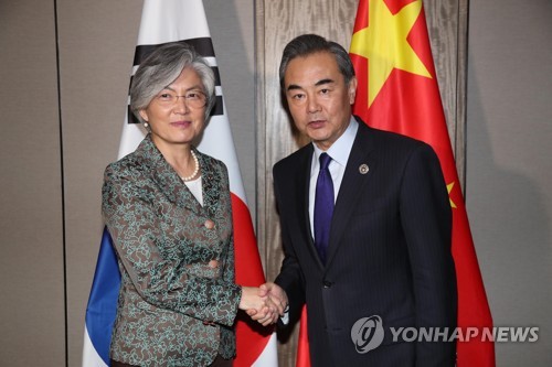 악수하는 강경화 장관과 왕이 외교부장