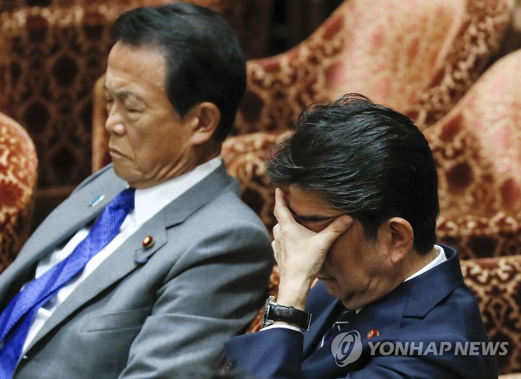 작년 아베 신조(安倍晋三) 일본 총리(오른쪽)가 국회에 출석해 고개를 숙인 채 얼굴을 손으로 가리고 있는 모습. 사진 왼쪽은 아소 다로 부총리 겸 재무상. [EPA=연합뉴스 자료사진] 
