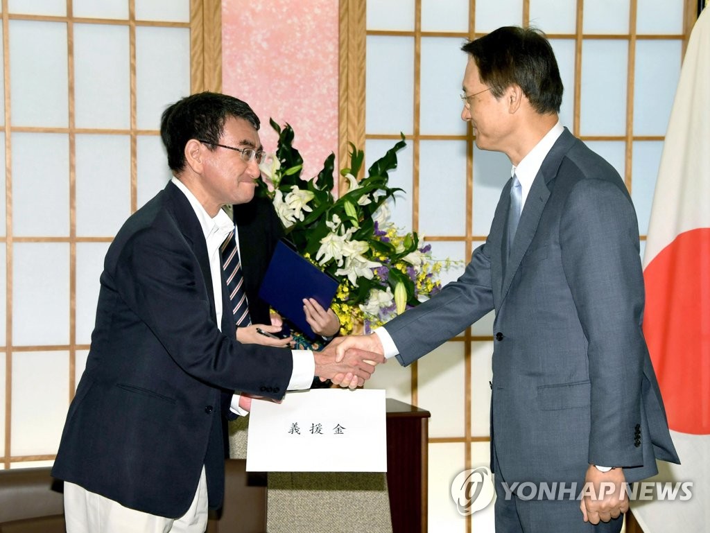 악수하는 이수훈 주일대사와 고노 일본 외무상