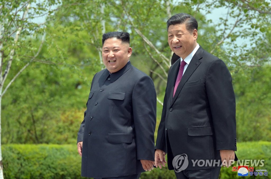 In this file photo, taken on June 21, 2019, and released by the North's official Korean Central News Agency, Chinese President Xi Jinping (R) and North Korean leader Kim Jong-un take a walk at the Kumsusan State Guesthouse in Pyongyang. (For Use Only in the Republic of Korea. No Redistribution) (Yonhap)