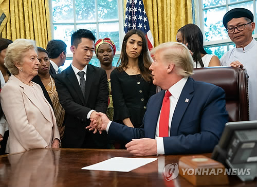 북한 종교탄압 피해자 주일룡씨와 악수하는 트럼프
