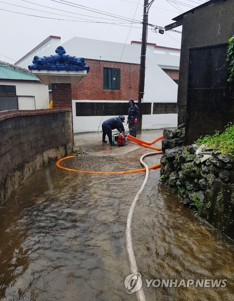 Firefighters pump water from yard on Jeju Island Firefighters pump water from yard on Jeju Island
