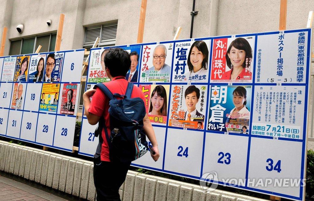 (도쿄 AFP=연합뉴스) 아베 신조(安倍晋三) 총리 정권의 중간평가 성격을 띠는 일본 참의원(상원 해당) 선거일인 21일 도쿄에서 한 남성이 선거벽보 옆을 지나고 있다. bulls@yna.co.kr